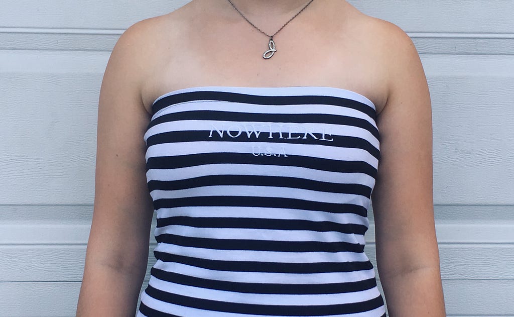 A black and white striped tube top that has the words “No Where U.S.A.” printed on it.
