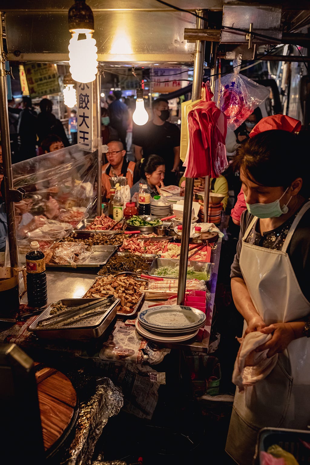 a colorful night market stand in Asia with various ingredients laid out for customers to choose from