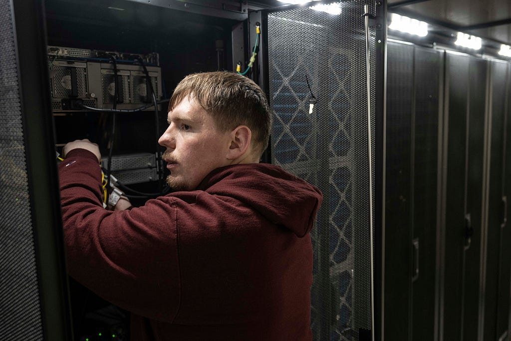 Jace Reddick works on a bank of servers.