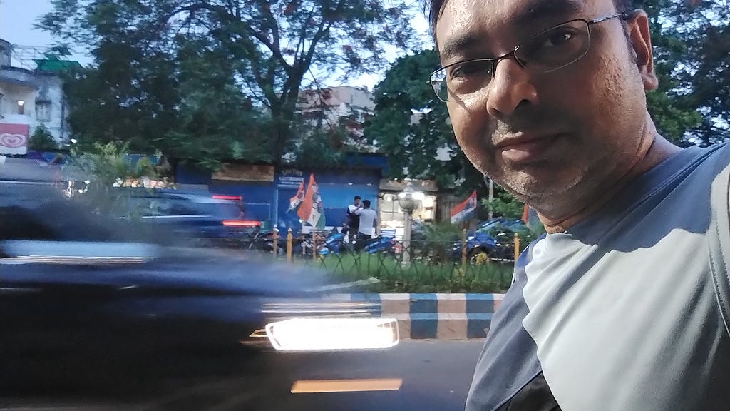 A selfie showing a car whizzing past in the background