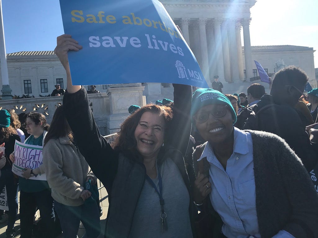 Two women stand outside the Supreme Court with pro-choice signs.