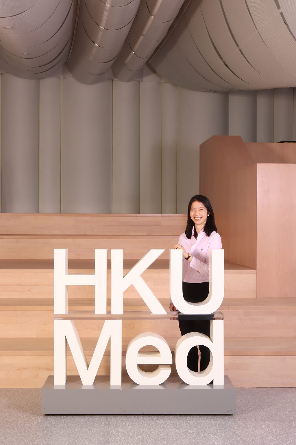 Dr Esther Chan Wai-yi stands in the main lobby of HKUMed faculty building.