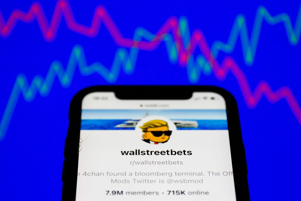 WallStreetBets forum on the Reddit displayed on a phone screen and a illustrative stock chart in the background