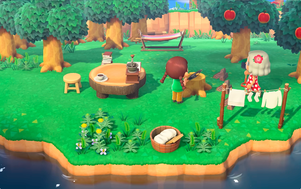 An isometric Animal Crossing: New Horizons scene showing a player character near a tree stump table with a coffee cup and books, beside a villager hanging laundry, surrounded by fruit trees and wildflowers at the island’s edge.