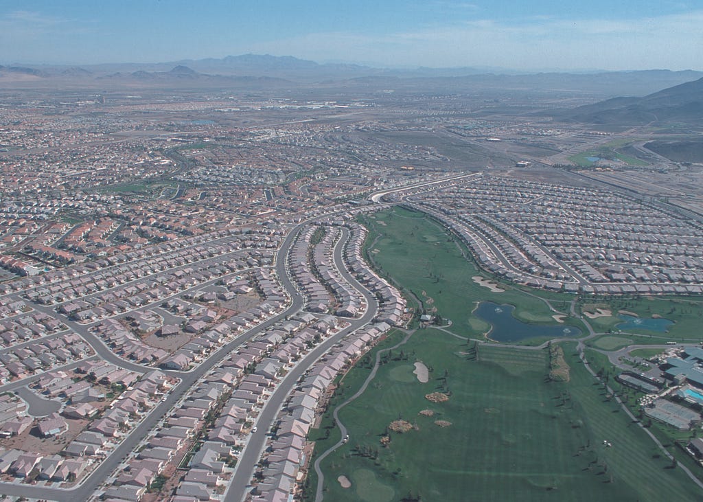 Aerieal view of sprawling suburbs. Near identical houses over and again for miles.