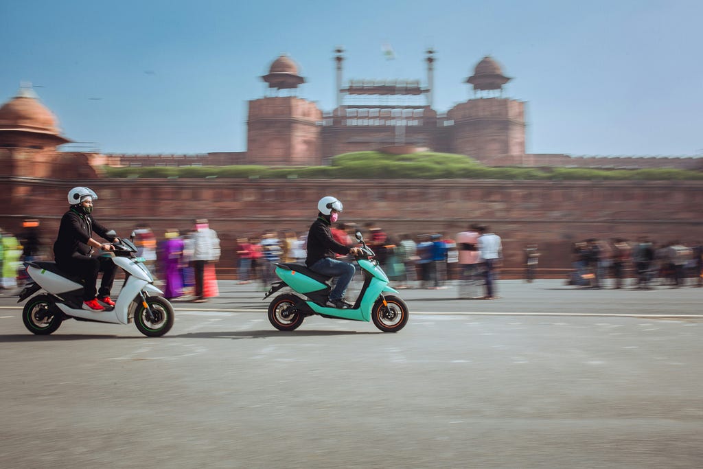 Two electric scooters with Delhi’s Red Fort in the background