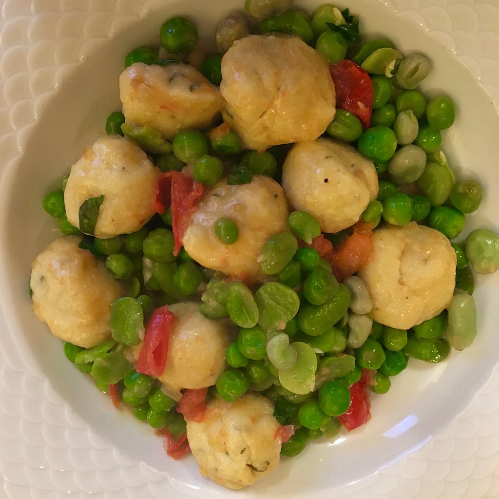 The peas and dumplings on a dinner plate.