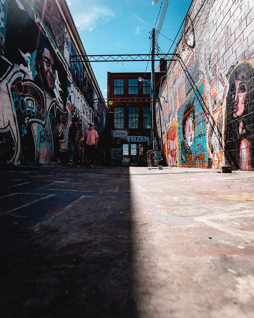 graffiti laden street slit between light and shadow side