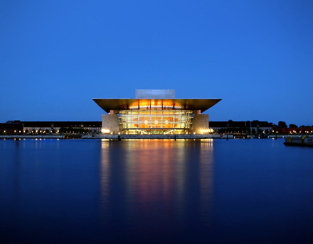 Henning Larsen’s Copenhagen Opera House at night from across the harbor