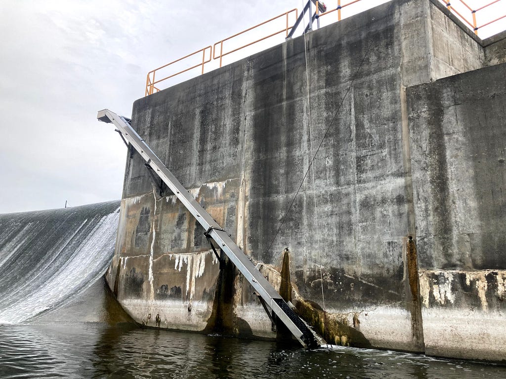 a tall, square ladder on the side of the dam