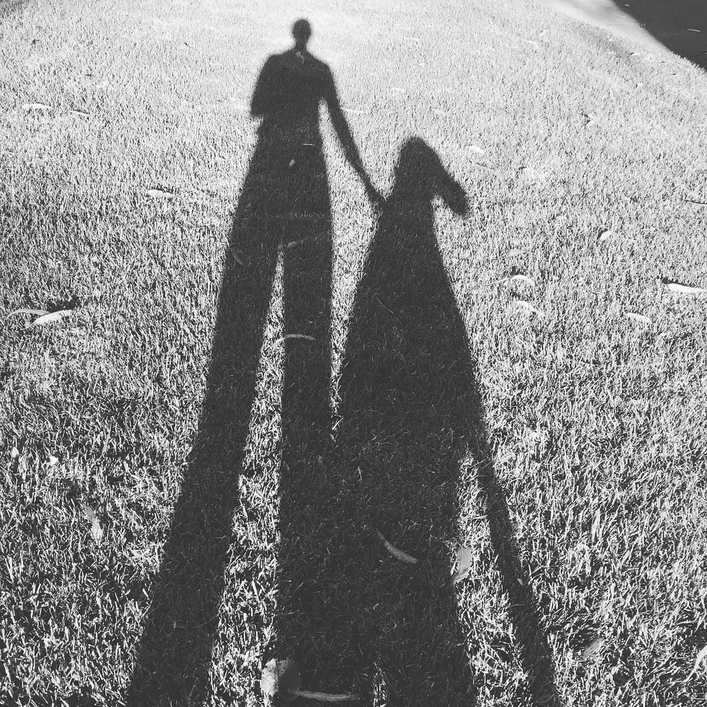 A black and white photo of the author’s shadow along with her dog’s shadow.