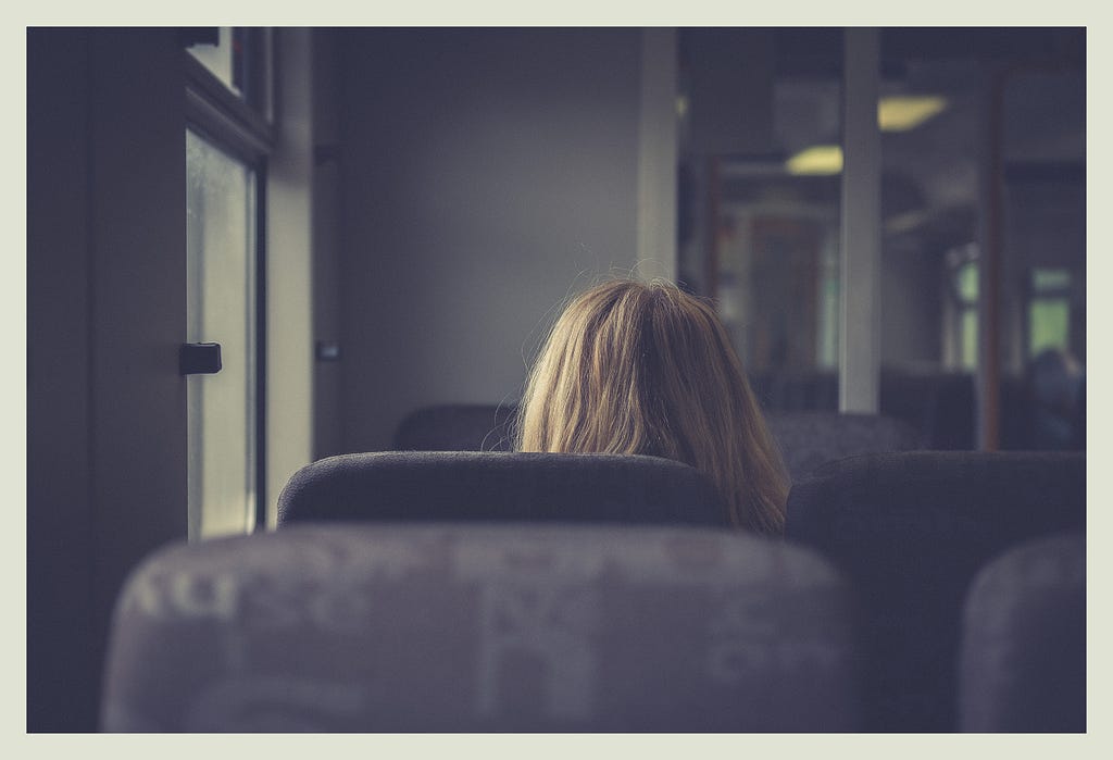 Woman sitting alone in i train cabin.
