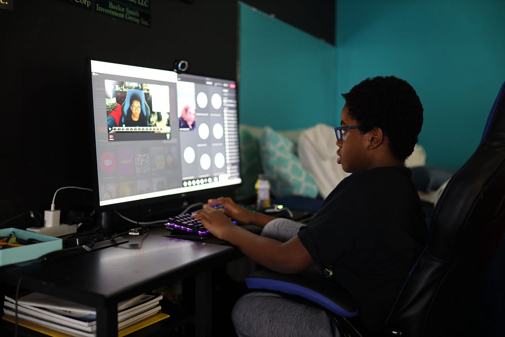 Young man sitting in front of a computer on a conference call