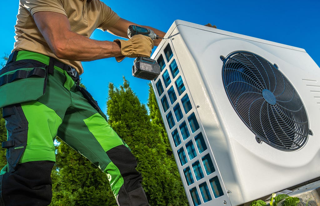 A technician installing a heat pump