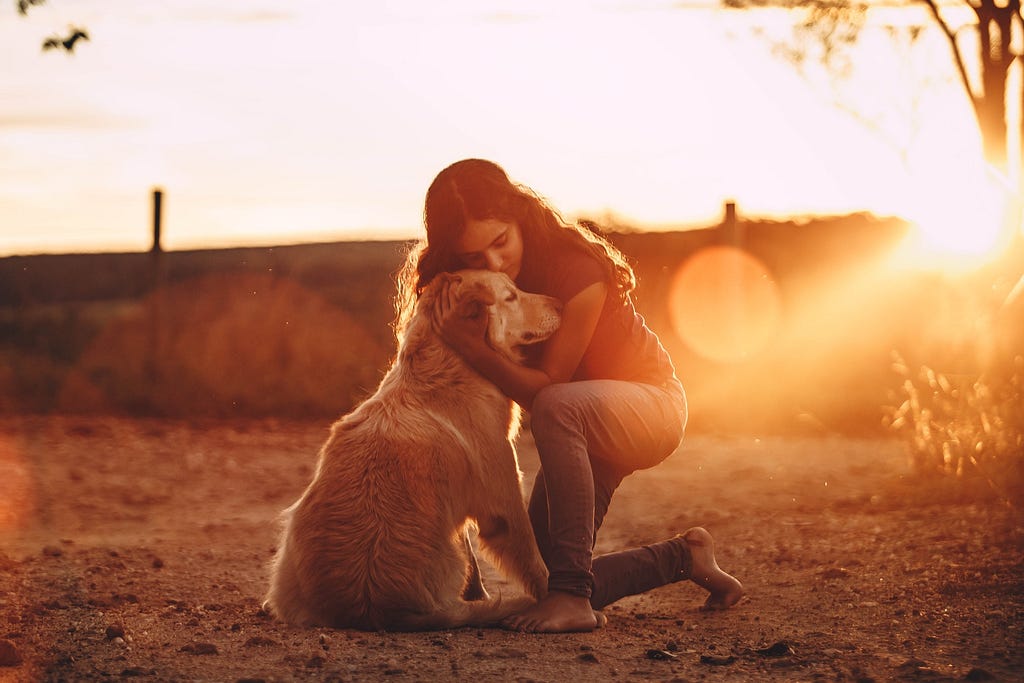 Woman hugging a golden retriever dog