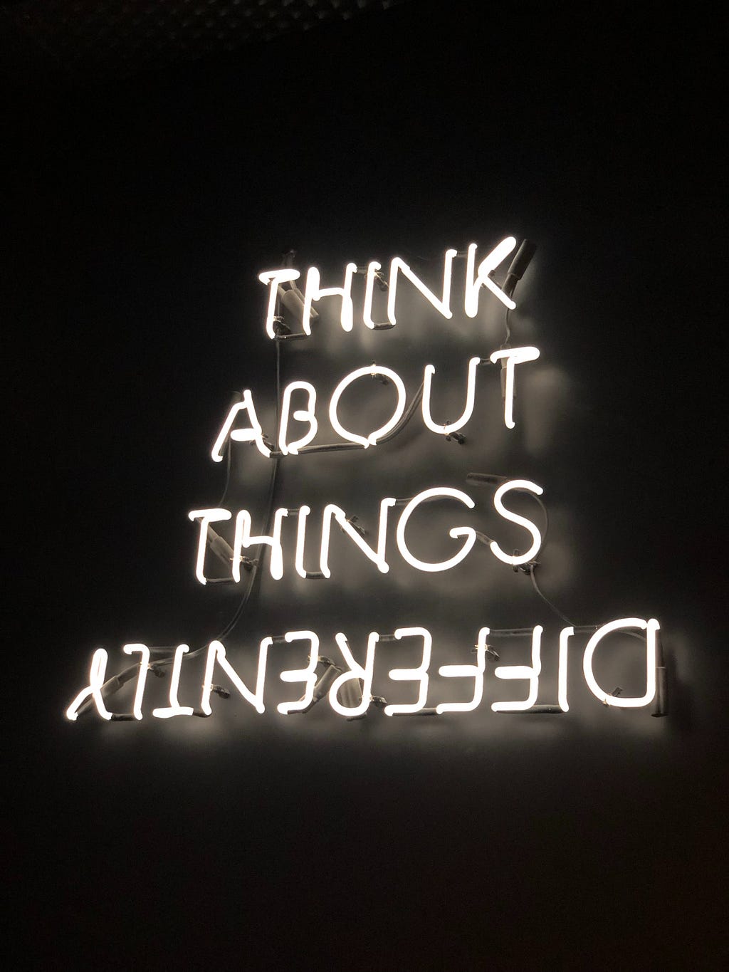 Neon lights showing “Think about thinks Differently” (Differently is written upside down)