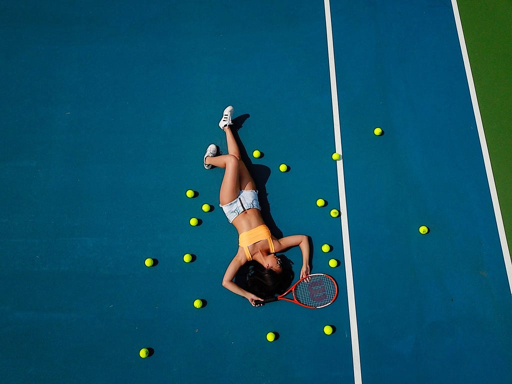 Girl laying down on a tennis court