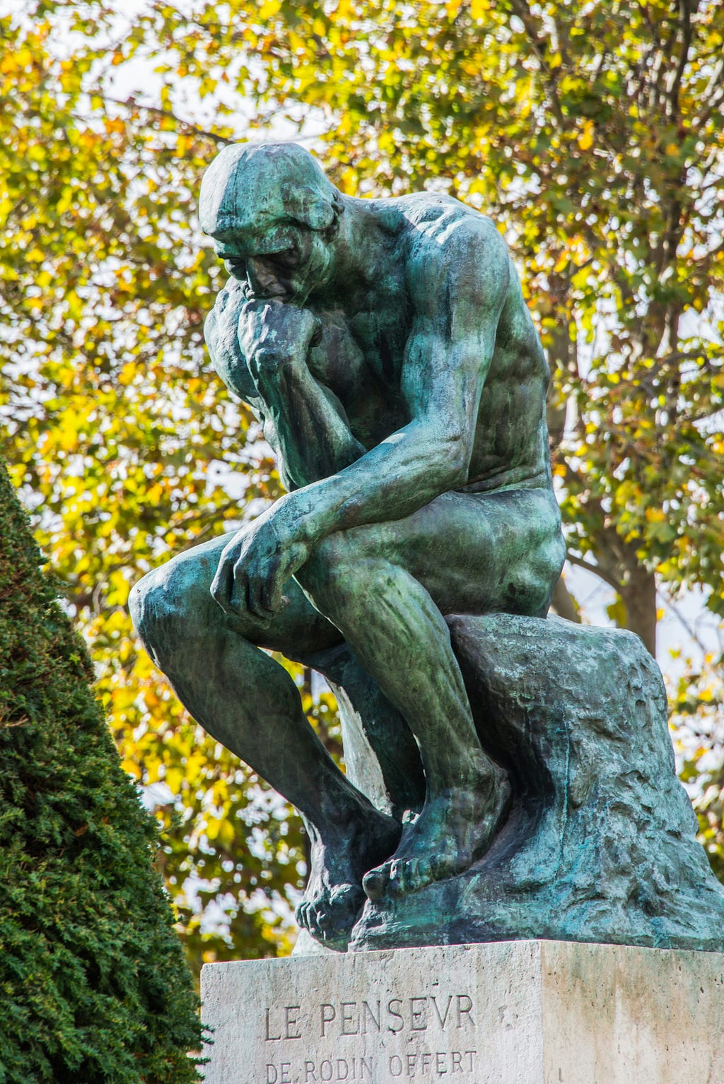 Rodin’s famous sculpture of “the Thinker” (Le Penseur) in a park in Paris.