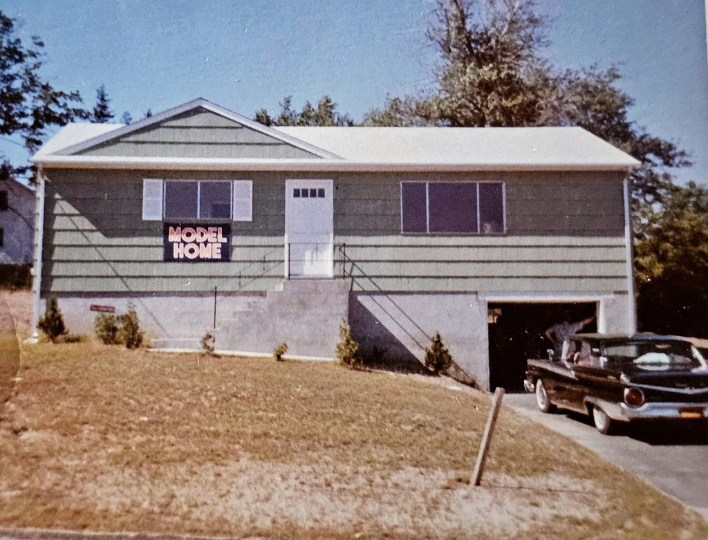 House where I grew up, with “model home” banner — part of early 1960’s New York City suburban development.