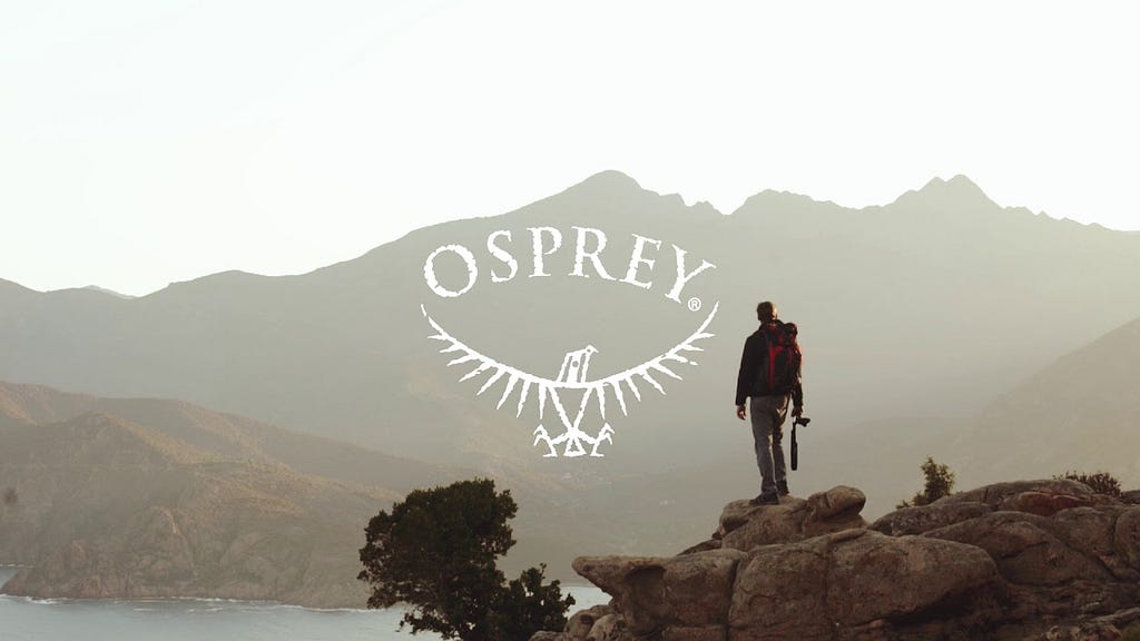 Man standing on the rock with Osprey backpack