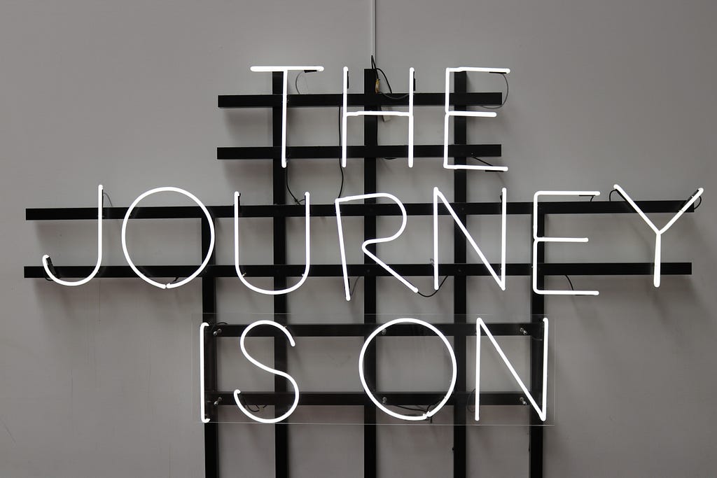 Neon sign that’s off and reads “The Journey is On.”