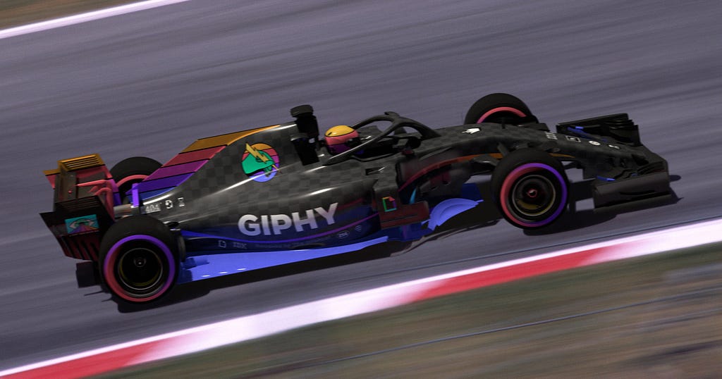 A race car with the GIPHY logo on the side of it on a racetrack. The car is in motion and appears to be speeding down the track.