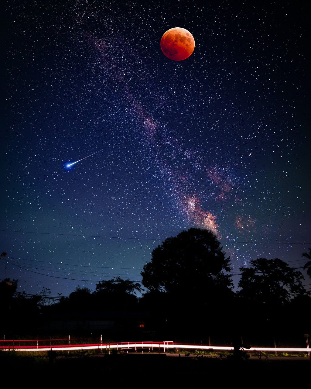 This is an image of the sky at night. There are a lot of bright stars in the sky. On the one hand, we can see the red moon. On the other hand, we can see an asteroid falling from space to the earth. The image has been taken from the ground where we can also see trees appearing black.