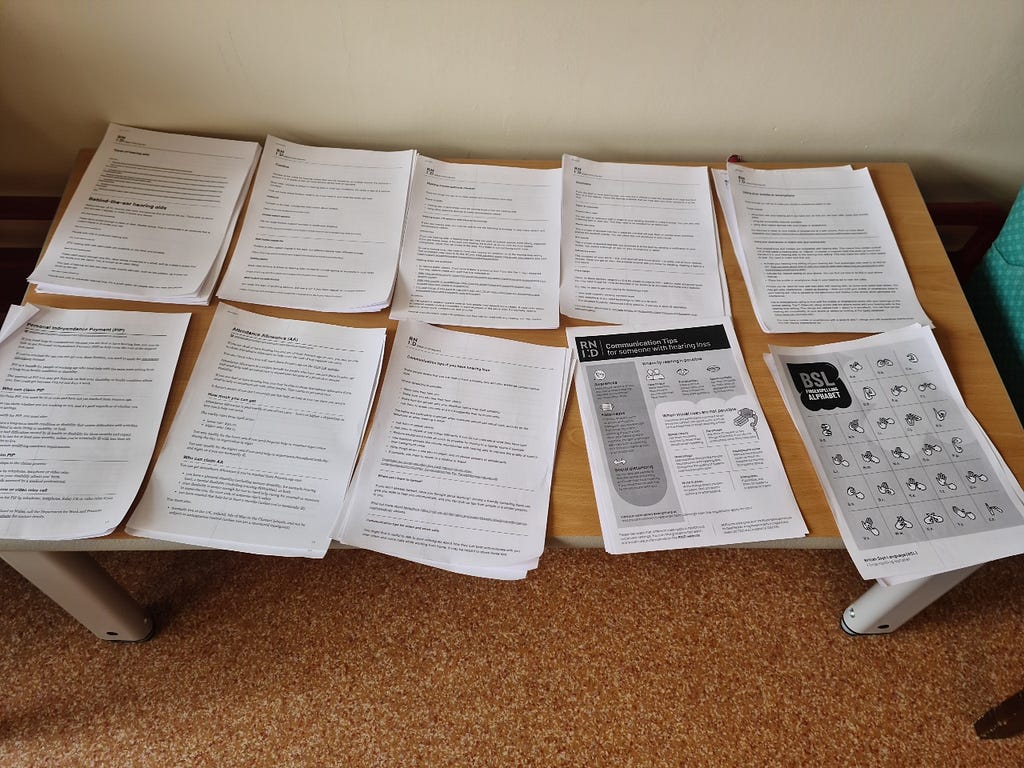 A table with 10 different types of printed information leaflets on it