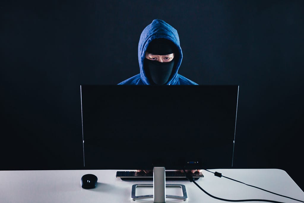 Man in mask sat at a computer clicking on ads for social care services