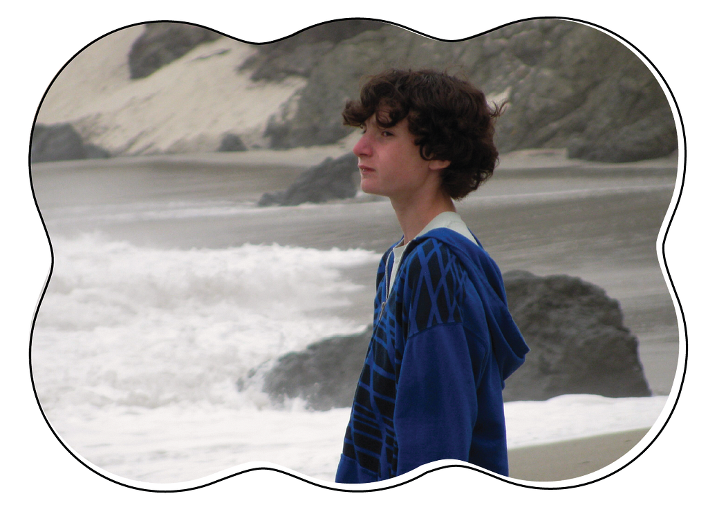 Young teenage boy looking serious on a chilly beach.