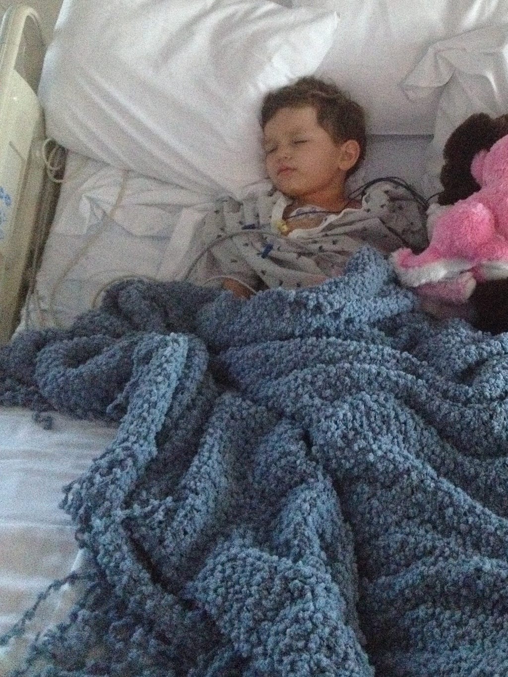Little boy with cancer laying in bed.
