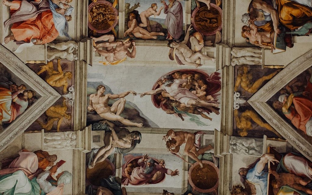 The ceiling of the sistine chapel painted by Michaelangelo, featuring God reaching out and touching fingers with Adam.