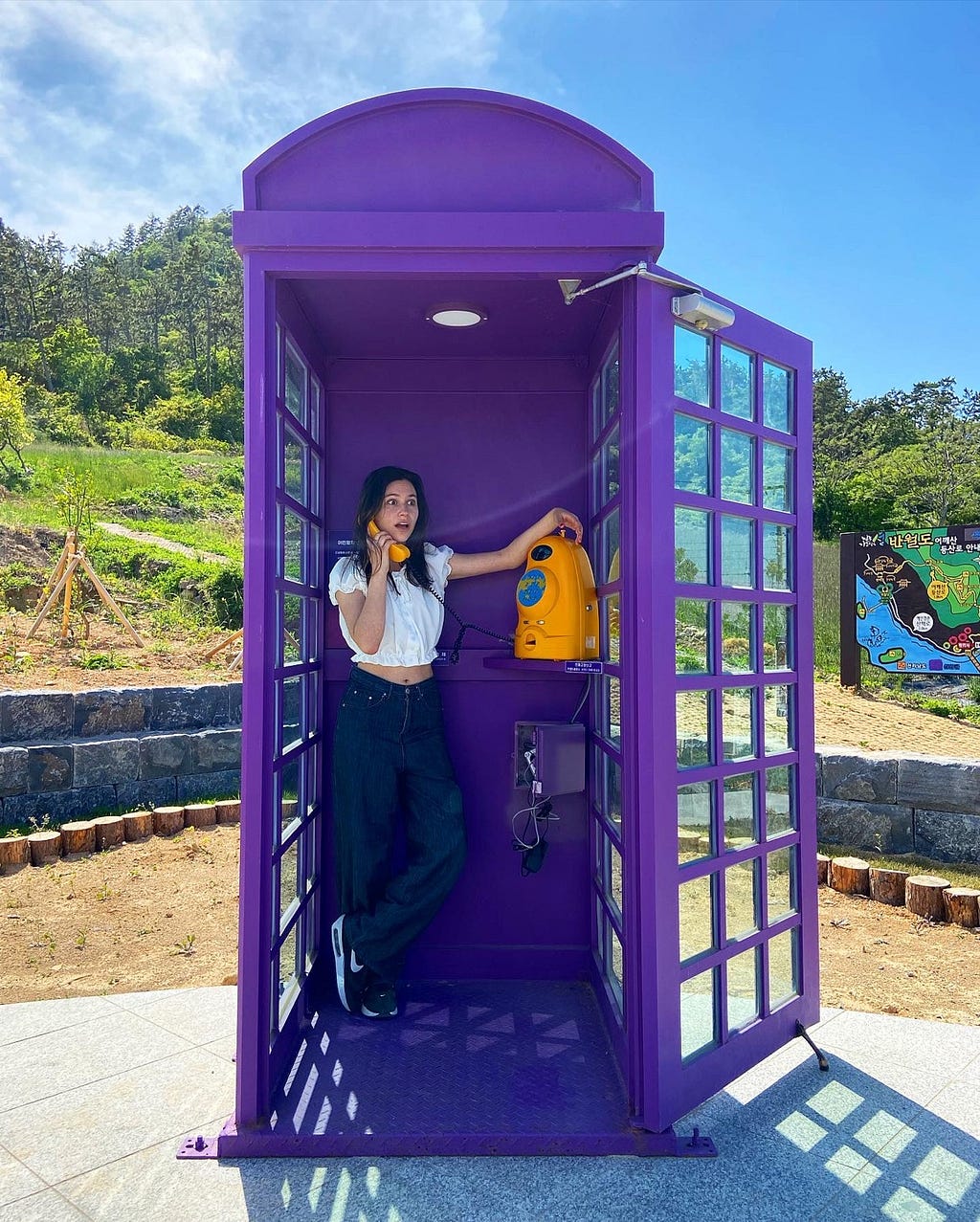 My friend is posing in a purple phone booth, pretending to be shocked for what she’s hearing in the phone call.