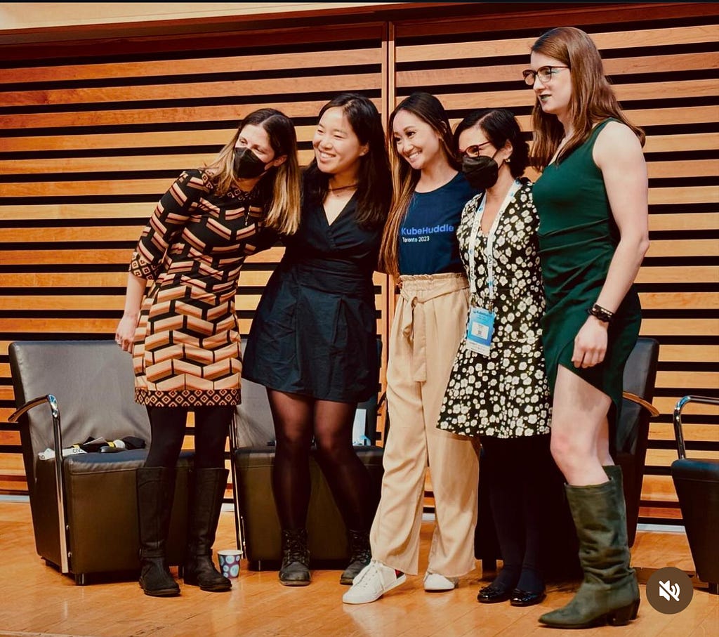 Five women in a panel at a conference