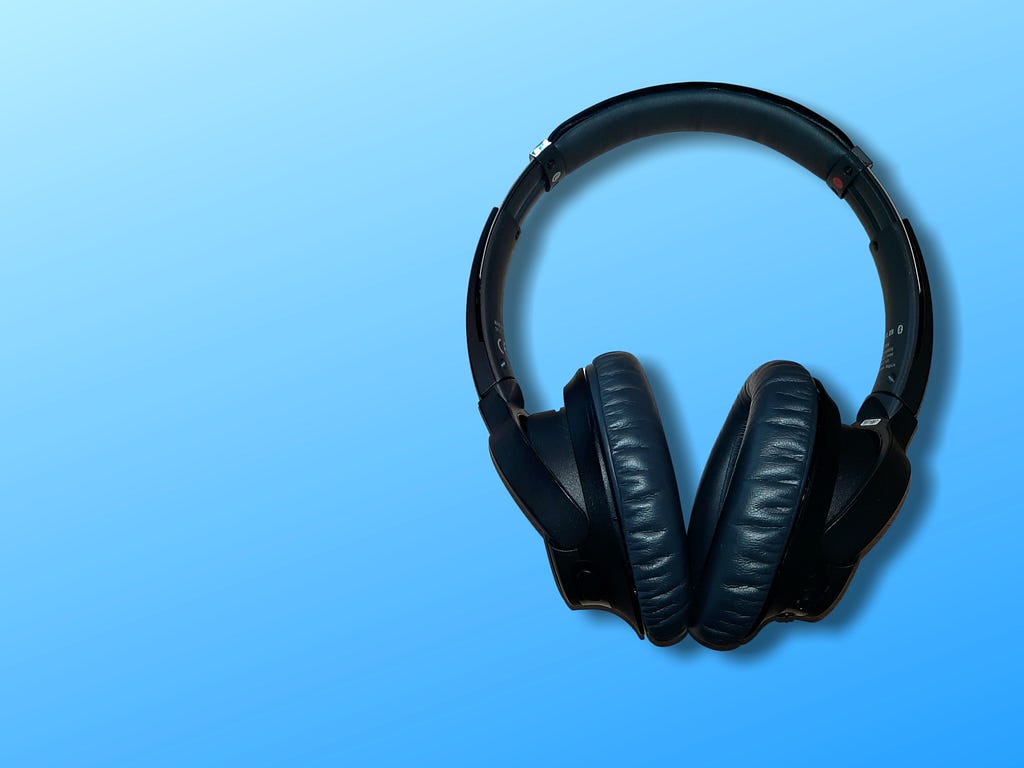 A black headset on the sky blue background.