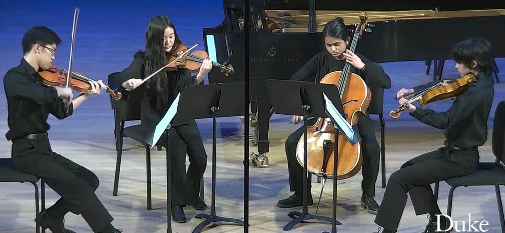 Tulio playing the viola with 3 other students