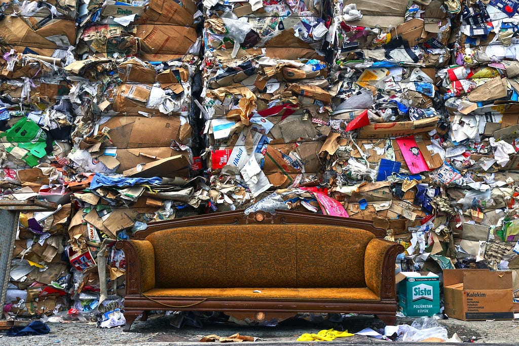 brown couch in front of piles of trash