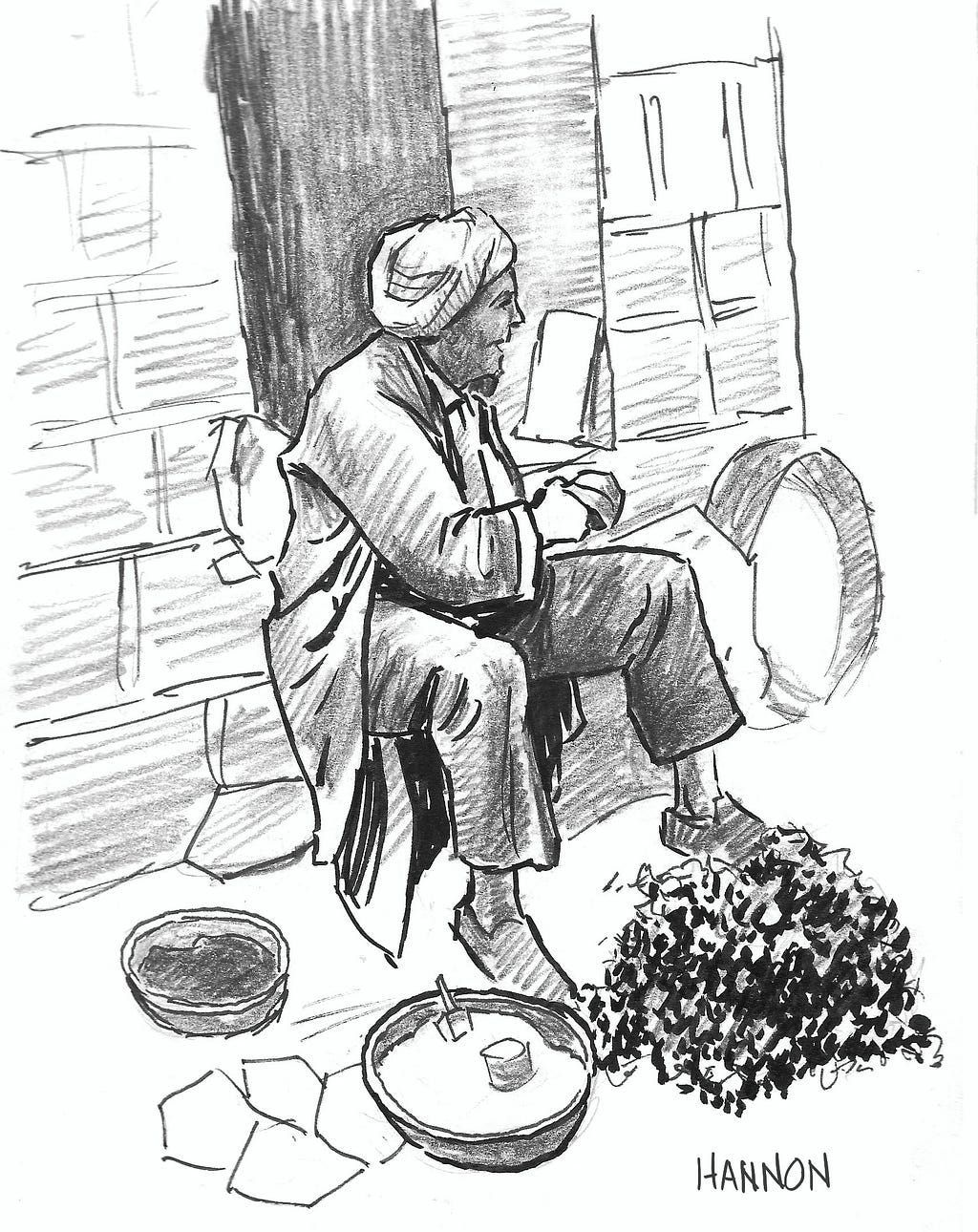 A merchant in an open-air market is selling spices in bowls and fresh mint in a pile, both placed on the ground near his feet. He is wearing a turban and a long coat. He sits on a stone ledge attached to a stone block building behind him. Behind his head and shoulders is a rectangular opening in the building revealing the inside. No details can be seen inside the building.