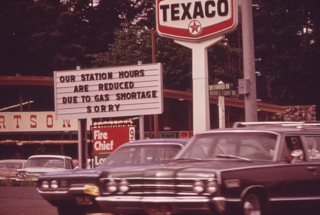 1970s vehicles parked outside of fuel stations closed due to shortage.