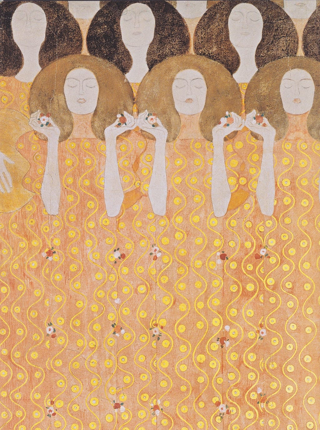Gustav Klimt’s Beethoven Frieze, Secession Building, Vienna, 2 rows of women with faces uplifted and eyes closed. Their dresses fused into one made of gold swiggles and circles dotted with small flowers