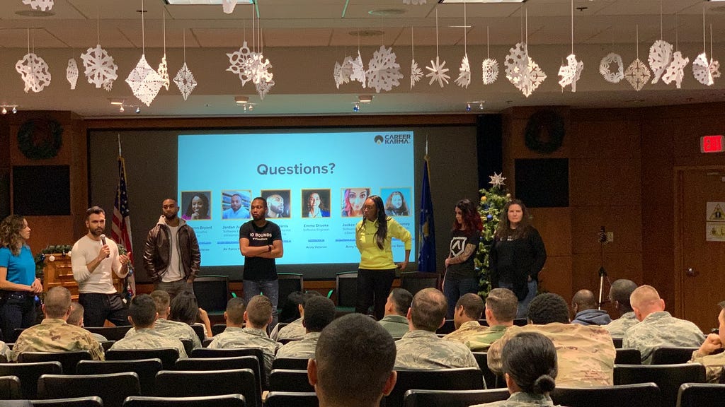 A panel of people talking in front of a group of air force personnel.