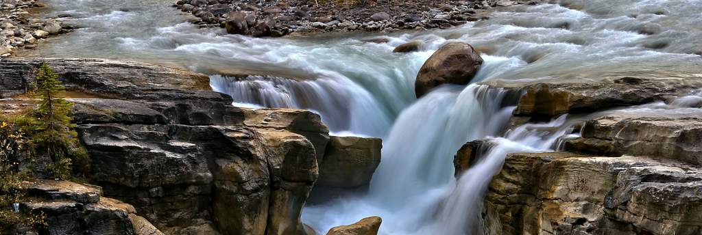 The image captures streams naturally coalescing into a waterfall. It is gentle before things begin to move faster, this is similar to data networks and streaming environments.