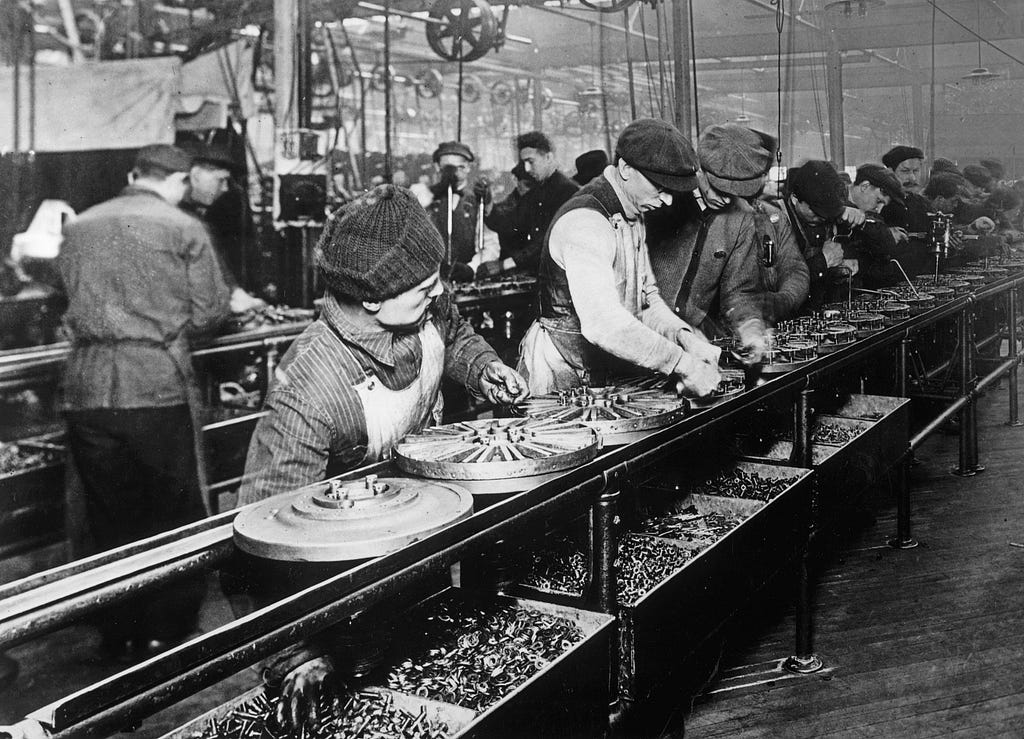 factory workers assembling a car on an assembly line