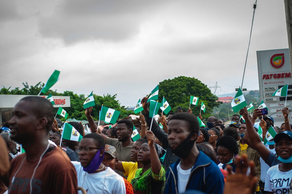 People marching and holding flags of Nigeria