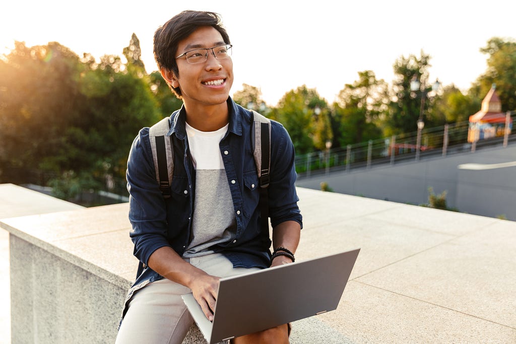 Student outside using laptop