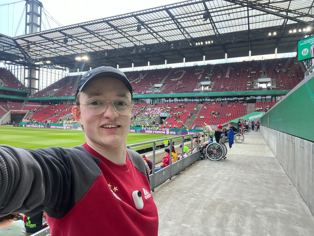 Ein Selfie von den Rollstuhlplätzen mit diesen und dem Stadion im Hintergrund.