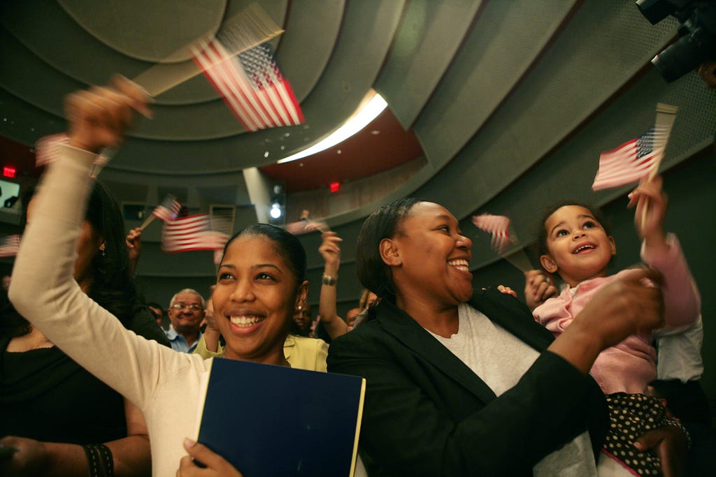 Group of people waving American flag after passing citizenship test