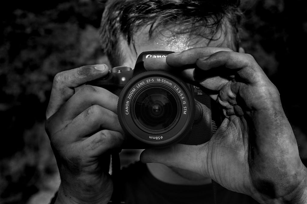 Man holding a camera to focus