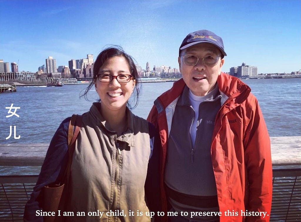 Chinese woman on left and Chinese man on right standing in front of water and skyline.