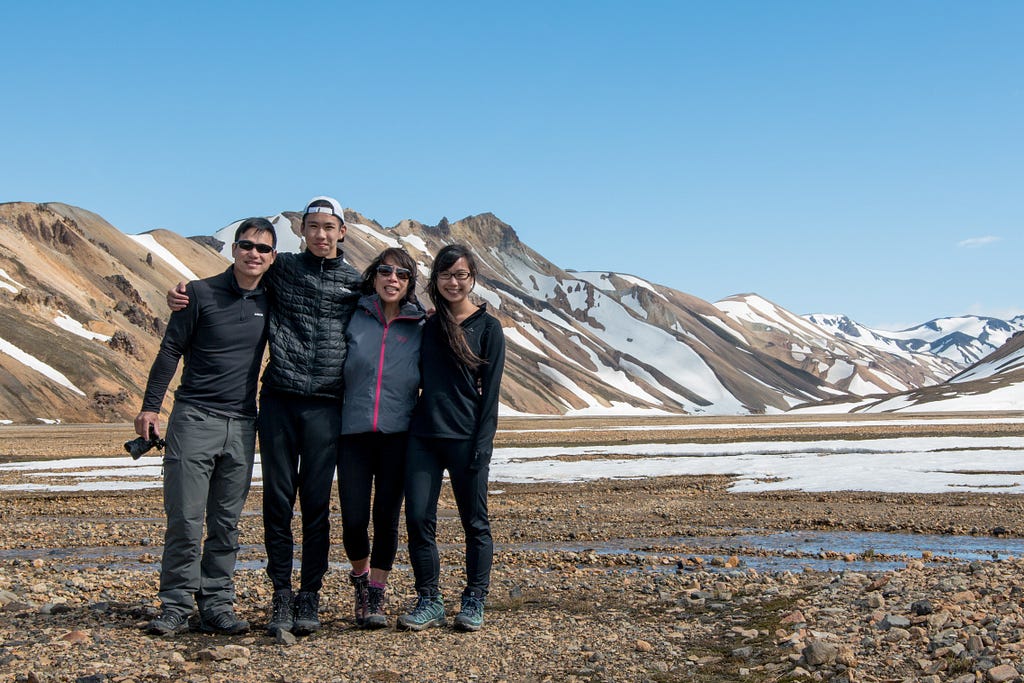 as asian family of four with a caramel icing mountain background.